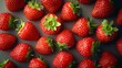 © Serjio - Una vista de arriba de fresas frescas dispuestas en un fondo oscuro, resaltando su color rojo vibrante y hojas verdes.