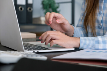 A woman calculating numbers in the office.