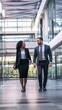 © Felippe Lopes - A man and a woman in business attire walk and talk in a modern office building.