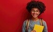 © Mane - Portrait of a smiling schoolgirl with an afro hairstyle, wearing a backpack and glasses isolated on a red background.