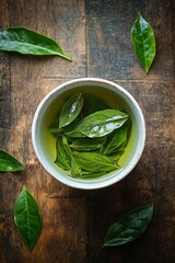 Canvas Print - Warm cup of green tea surrounded by fresh leaves on a wooden surface in a cozy setting