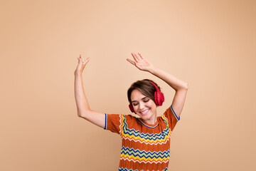 Poster - Portrait of pretty positive person beaming smile closed eye enjoy music headphones dance isolated on beige color background