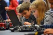 © Abdul - A group of young students learning coding and robotics in a modern classroom, surrounded by programmable robots, laptops, and digital tools