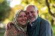 © Martí Rosselló - Happy Senior Couple Embracing Outdoors in Sunny Park, Smiling senior couple warmly embracing in a park, enjoying a sunny day. The man wears a scarf, and the woman a floral headscarf.