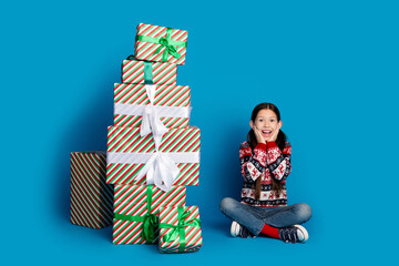 Poster - Photo of lovely shocked cute girl wear ugly ornament sweater receive many christmas gifts isolated on blue color background