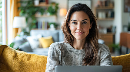 Poster - A woman is sitting on a couch with a laptop in front of her