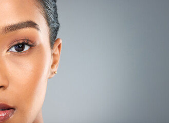 Poster - Woman portrait, beauty and half face in studio, makeup transformation and dermatology on gray background. Female person, mockup space and serious cosmetics for aesthetic, facial treatment and change