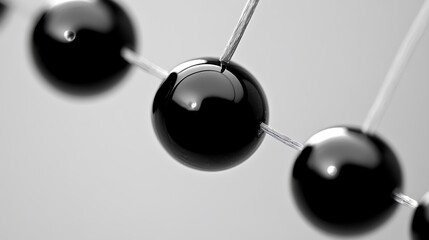 Close-up of a black Newton's cradle with a single ball swinging.