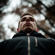 © Ideal & Ideas - A man in a jacket, captured from a low angle, looking upward with a calm and focused expression.