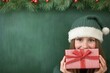 © Konstiantyn Zapylaie - Smiling woman holding gift box in festive christmas hat against holiday background