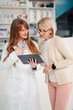 © Zamrznuti tonovi - Young druggist with tablet having consultations with senior woman.