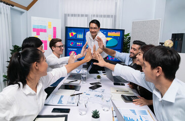 Analyst team leader celebrate with his colleague after successful data analysis meeting using FIntech software power with business intelligence or BI dashboard. Prudent