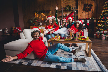 Canvas Print - Full body photo of cheerful young people friends group have fun playful celebrate cozy christmas party decor spacious apartment indoors