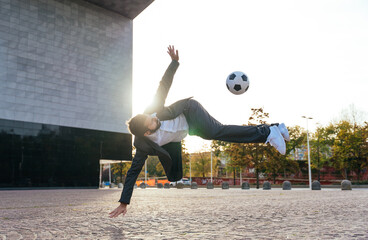 Businessman playing with a soccer ball and making freestyle tricks