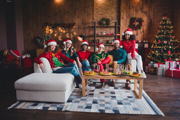 Canvas Print - Full body photo of cheerful young people friends group sit couch celebrate cozy christmas party decor spacious apartment indoors