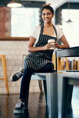 Wall Mural - Woman, coffee and waiter in cafe for professional service, catering and portrait on lunch break with apron. Employee, face and smile in bakery for small business, happy and working with cup of latte