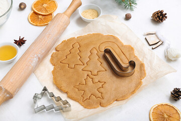 Composition with raw dough, spices and utensils for preparing Christmas cookies on light background