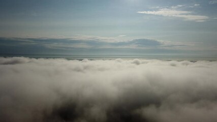 Wall Mural - Aerial flight above fog clouds in the morning with blue sky background