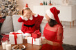 © Pixel-Shot - Young mother greeting her little daughter with Christmas at home