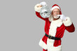 © Pixel-Shot - Santa Claus in glasses pointing at disco ball on grey background