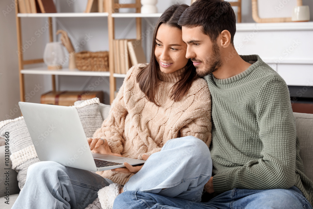 Loving couple using laptop at home on winter day