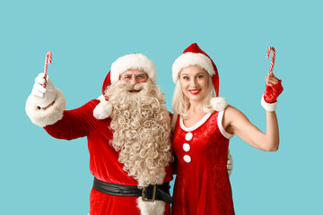 Wall Mural - Santa and MRS Claus with candy canes on blue background