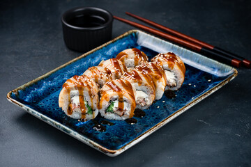 Wall Mural - Set of maki sushi rolls with tamago omelet, tuna, cream cheese, cucumber and teriyaki sauce.