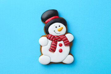 Sticker - Tasty Christmas cookie in shape of snowman on light blue background, top view