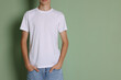 © New Africa - Teenage boy wearing white t-shirt on green background, closeup. Space for text