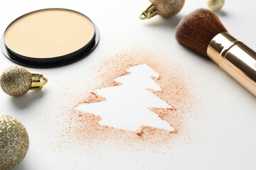 Christmas tree made of powder, balls and makeup brush on white background, closeup