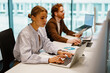 © Yaroslav Astakhov - In a sleek, modern office environment, two dedicated professionals remain intensely focused on their laptops