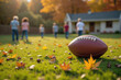 © Cozy Coffee Bar - Football lying on grass with family playing in background during autumn