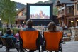 © InfiniteStudio - Families and couples enjoy an outdoor movie night under the stars in a picturesque setting with a large screen in view