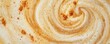 © NK - Aerial view of frothy creamy latte art with cinnamon swirl pattern, close-up. Coffee art and beverage concept