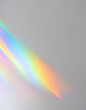 © Uuganbayar - Blurred rainbow light refraction texture overlay effect for photo and mockups. Organic drop diagonal holographic flare on a white wall.