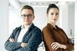 © Henhen - Two professionals standing back-to-back with arms crossed in an office setting.