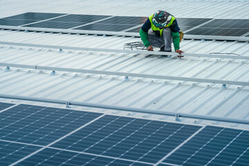 A worker installs or maintains solar panels on a rooftop. The image highlights renewable energy technology, solar power systems, and the role of workers in implementing sustainable energy solutions.