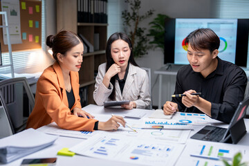 Wall Mural - Asian business team analyzing financial graphs and charts in modern office