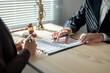 © Wasana - Lawyer explaining contract details to client in office