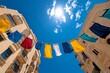 © Sanchai - Bright laundry hanging between two buildings, fluttering in the breeze