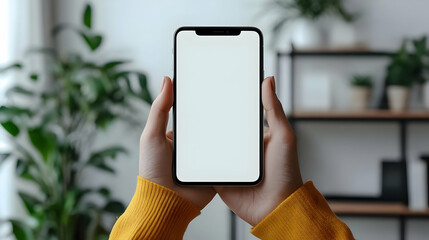 Poster - A person holding a blank smartphone in a cozy indoor setting.