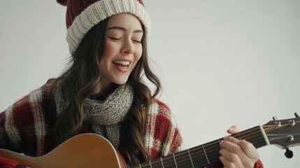 Young woman enjoying music in winter attire playing acoustic guitar