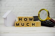 © may1985 - How Much? alphabet letters and magnifying glass and calculator on wooden background