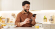 © WesLens/peopleimages.com - House, typing and man with smartphone, credit card and internet with social media, connection and payment. Apartment, person and guy with cellphone, ecommerce and message with transactions or banking