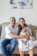 ndian family spending time together, wearing traditional and casual outfits with a baby, a young girl, and grandparents in a high-rise apartment in Kuala Lumpur, Malaysia.