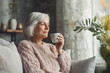© Di Studio - cute woman sitting on sofa and drinking tea at home