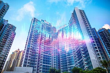 Sticker - Tall glass buildings with a light blue sky background, modern architecture in a Hong Kong cityscape.