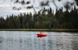 © Cavan Images - man in a life jacket rowing on a boat in autumn lake in Finland