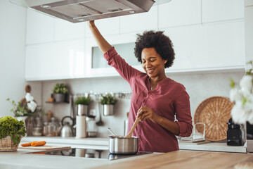 Woman Joyfully Cooking in Modern Home Kitchen Setting