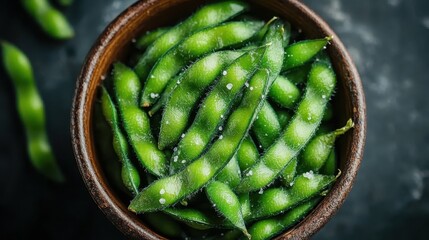 A bowl of salted edamame pods resting on a textured surface, exemplifying simplicity and health, ideal for promoting nutritious diets and organic lifestyles.